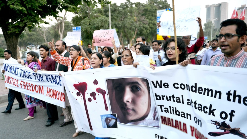 Pakistani activists carry banners during a rally against the assassination attempt on Malala Yousafzai.