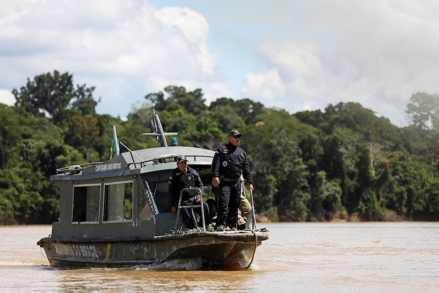 Authorities on small boat on the river.