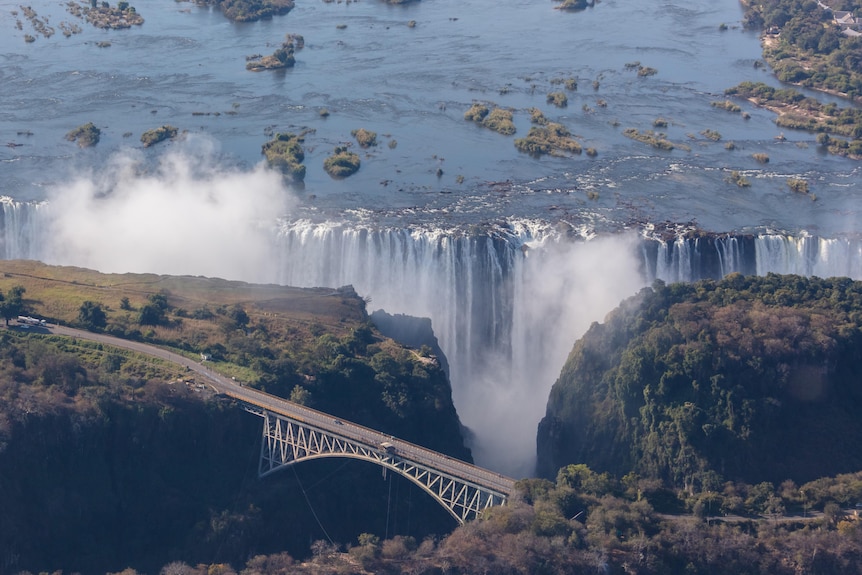 An aerial photograph of a large waterfall, with a bridge in front.