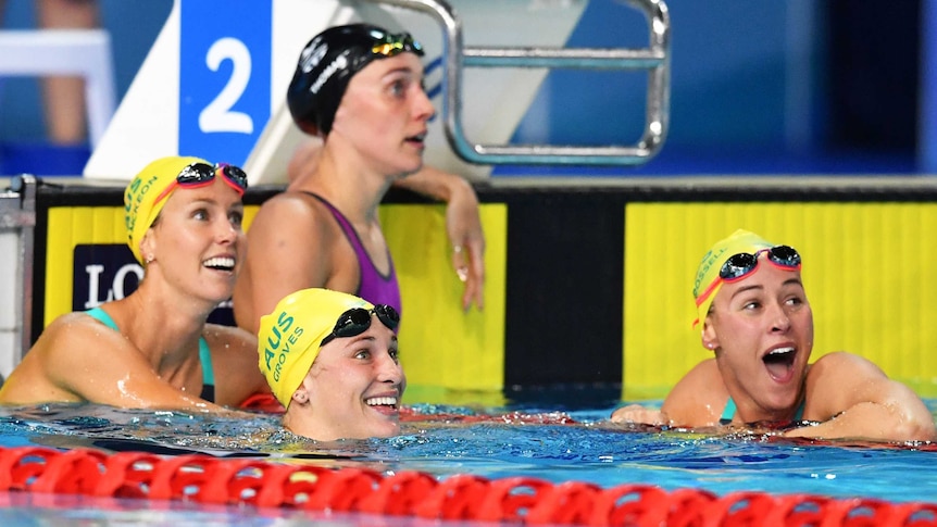 Emma McKeon, Madeline Groves and Brianna Throssell of Australia smiling in the pool after butterfly event.