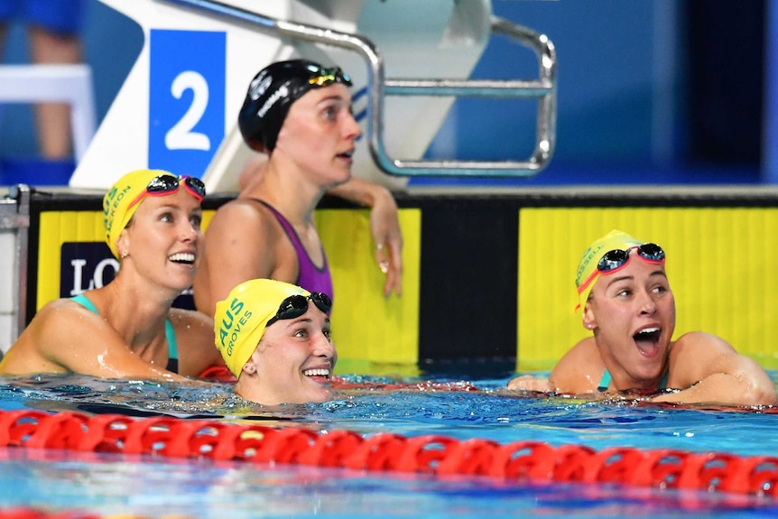 Emma McKeon, Madeline Groves and Brianna Throssell of Australia smiling in the pool after butterfly event.