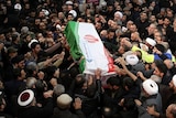 Thousands surround the coffin of Qassem Soleimani as it arrives for burial.