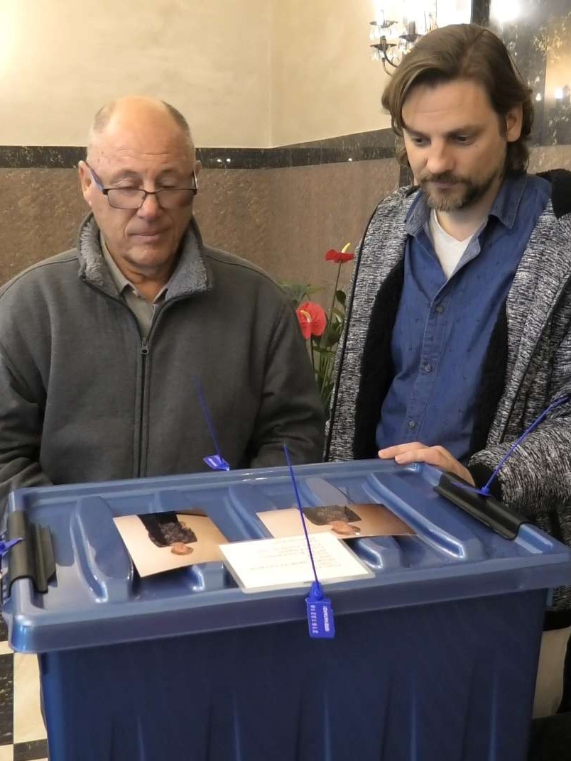 Two men look at a blue box.