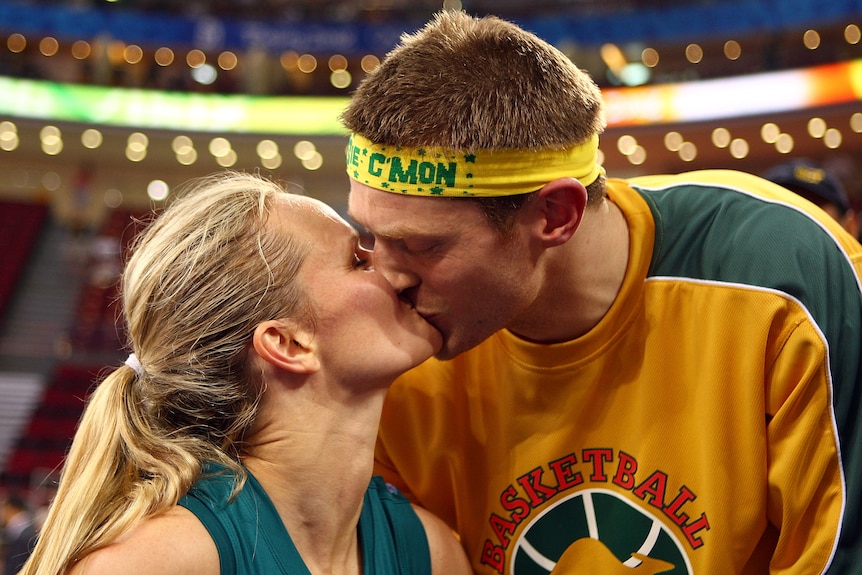 Jenni Screen kisses her husband Neil Mottram on the edge of the basketball court.