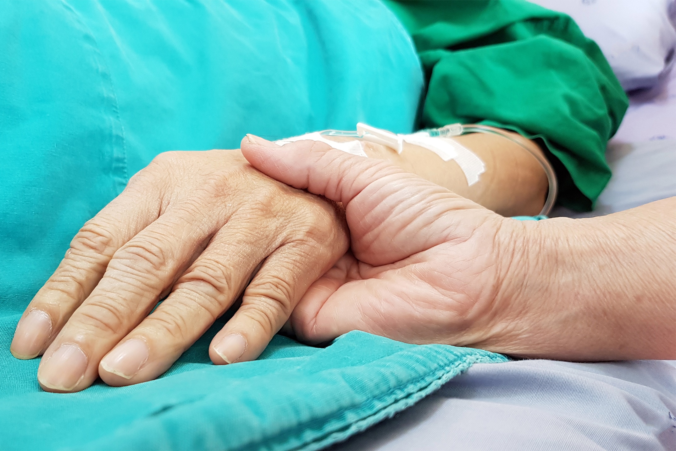 Two people holding hands in a hospital.