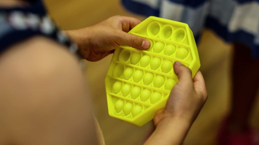 a person pressing into what looks like yellow plastic bubble wrap