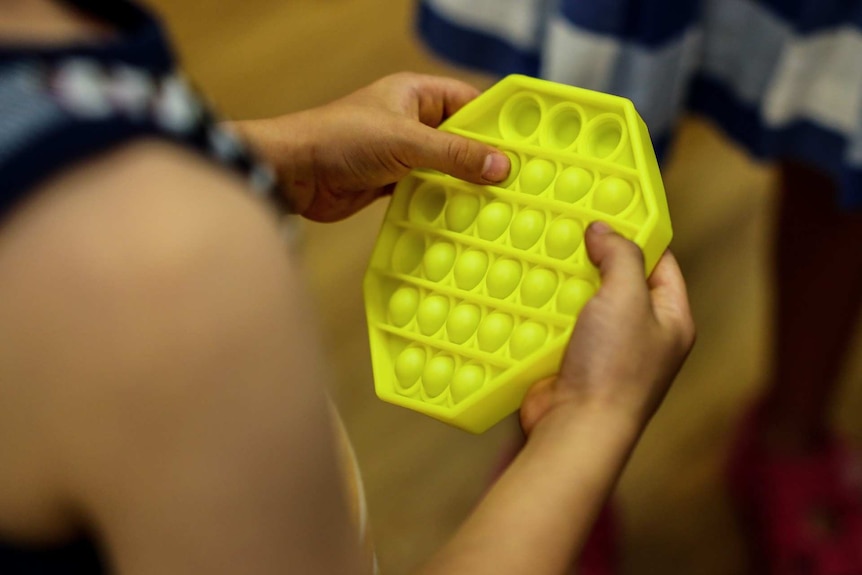 a person pressing into what looks like yellow plastic bubble wrap