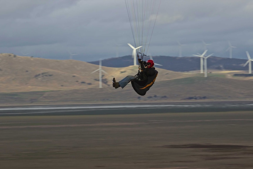 Paraglider with Capital Wind Farm in distance