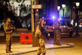 French soldiers with machine guns stand on the Champs Elysees