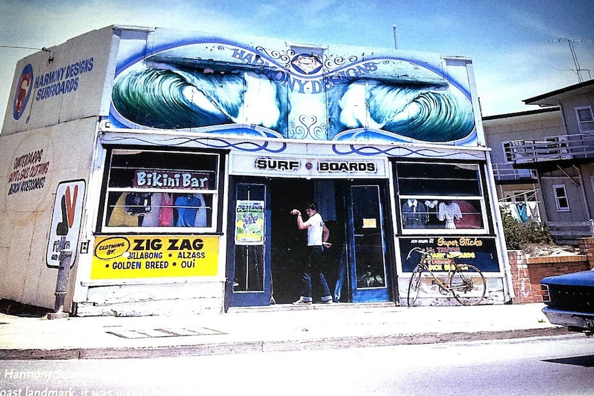 A man stands in the door of a surf shop