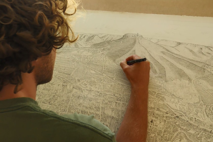A view looking over the shoulder of Alex Pescud drawing on his Wollongong map.