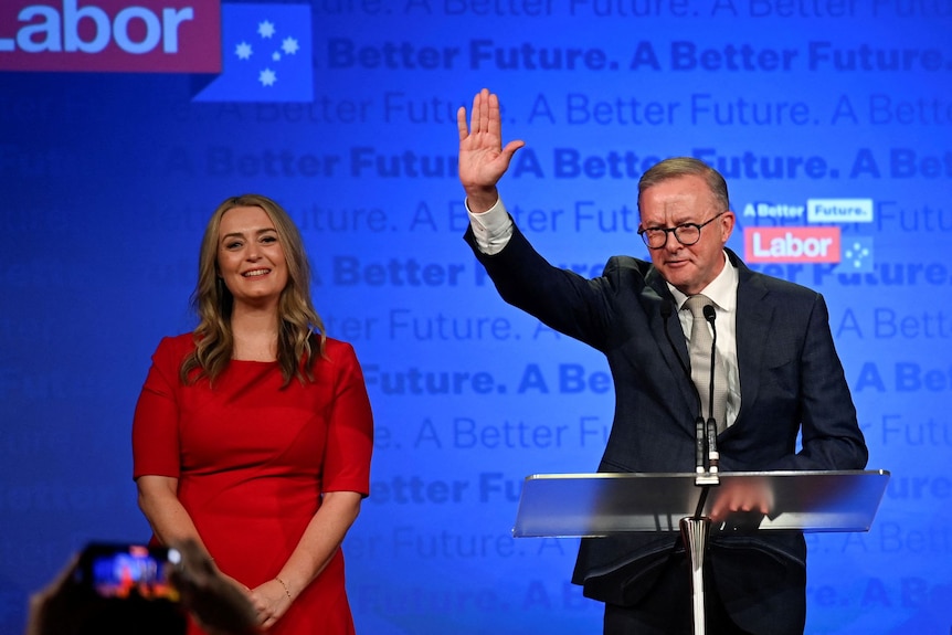 Anthony Albanese, leader of Australia's Labor Party stands next to his partner Jodie Haydon, while he addresses his supporters