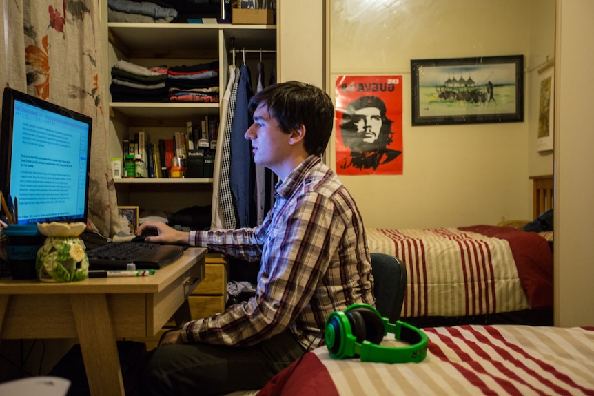 Jack Surplice studies on a computer in his room.