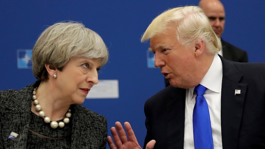 Theresa May and Donald Trump lean towards each other in conversation.
