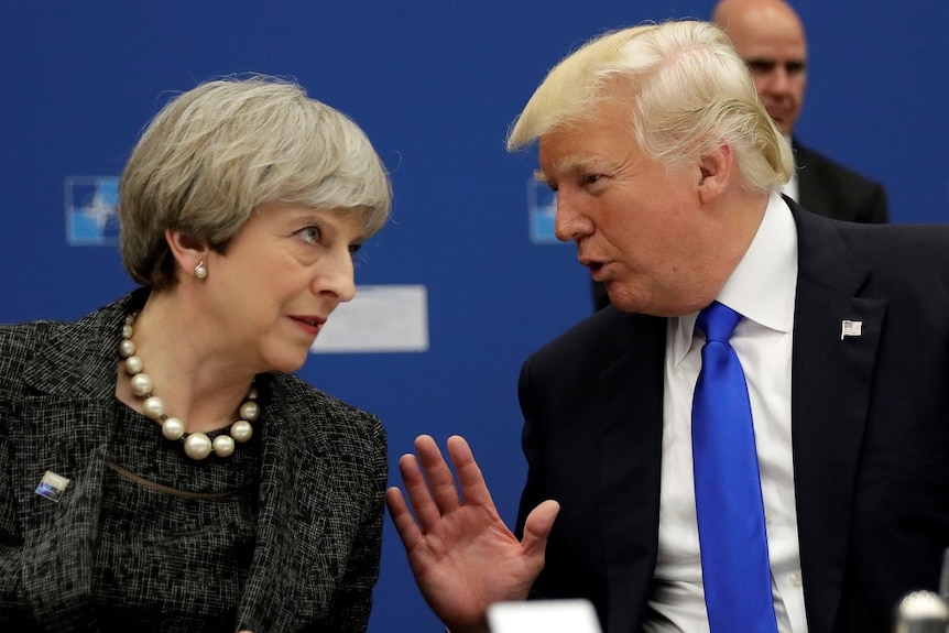 Theresa May and Donald Trump lean towards each other in conversation.