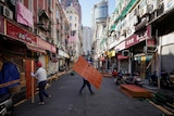 workers in hard hats remove fencing around shops in Shanghai street