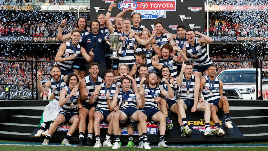 Geelong celebrates with the AFL trophy after winning the 2022 grand final.