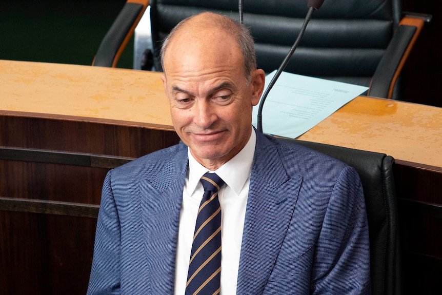 A man in a blue suit sits in Parliament