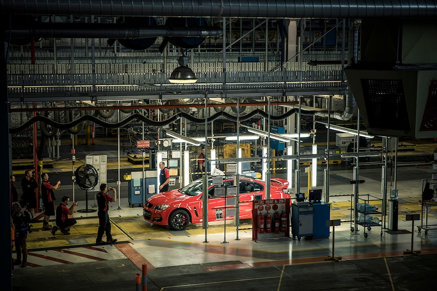 A red Holden car on a factory line.