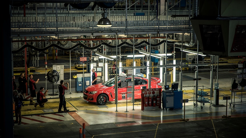 A red Holden car on a factory line.