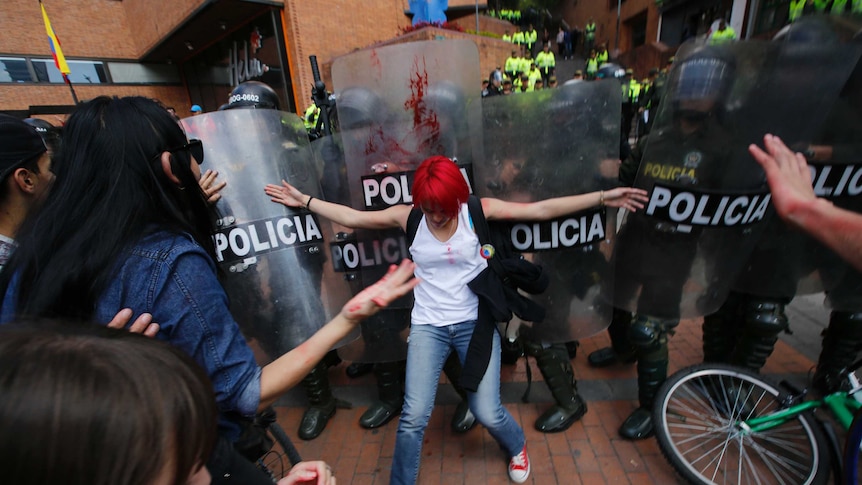 Woman fronts police with shields in protest to bullfighting in Bogota