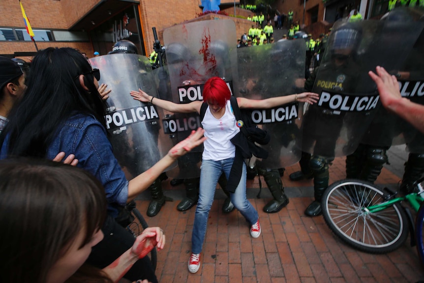Woman fronts police with shields in protest to bullfighting in Bogota