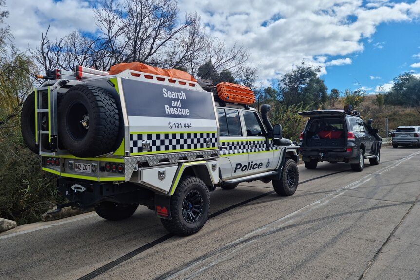 A police utility with the words search and rescue written on the side parked beside bushland.