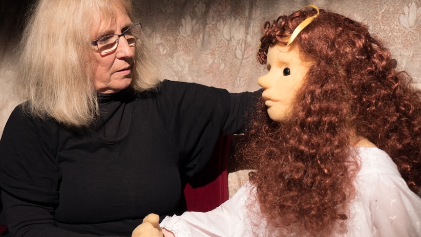 Sue Harris sits looking at her puppet Genevieve