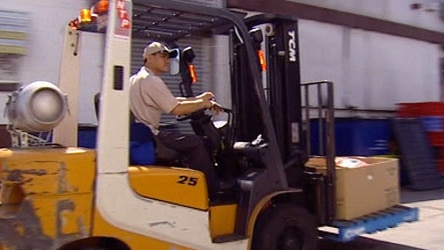 A forklift carries boxes