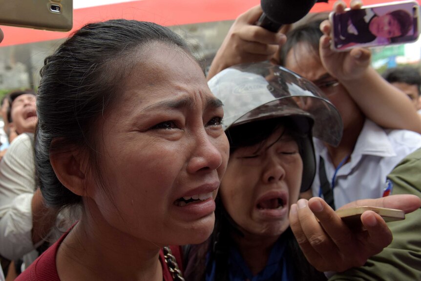 Cambodians gather outside a store where political analyst Kem Ley was shot dead in Phnom Penh.