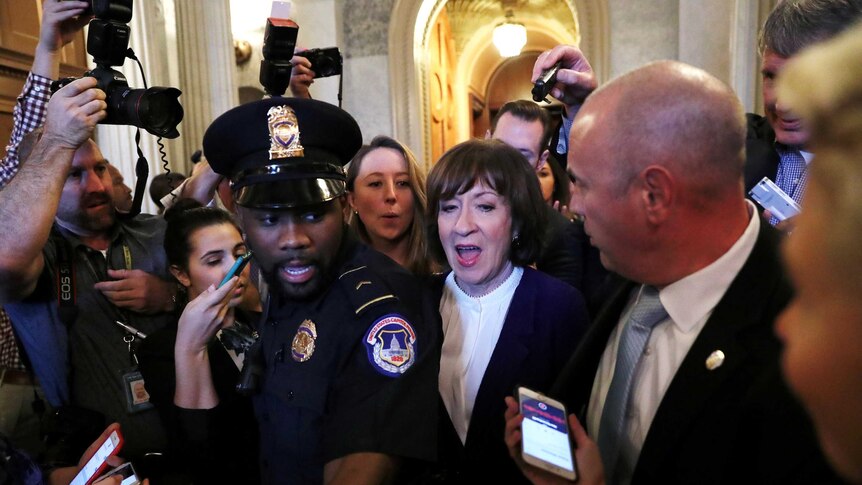 Susan Collins leaves the Senate floor surrounded by Capitol police and reporters