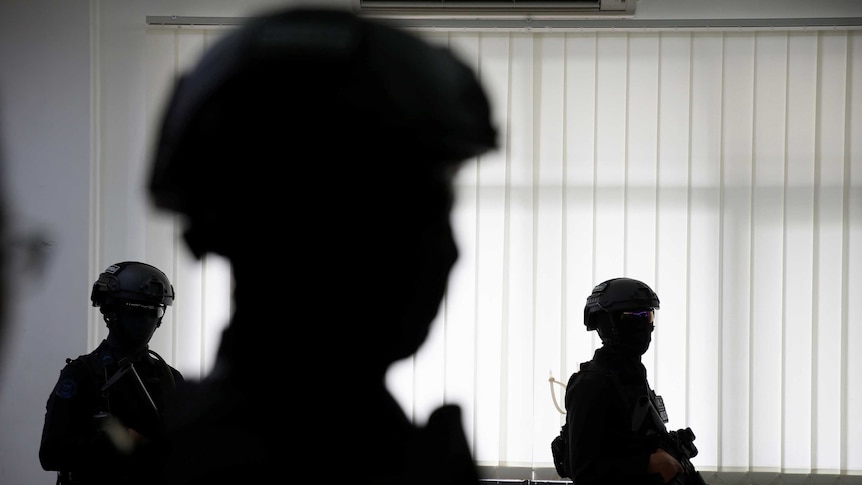 Anti-terror policemen stand at police headquarters in Jakarta.
