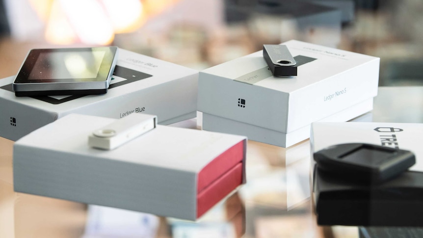 USB sticks and mobile devices sit on top of their packaging among an evidence stash
