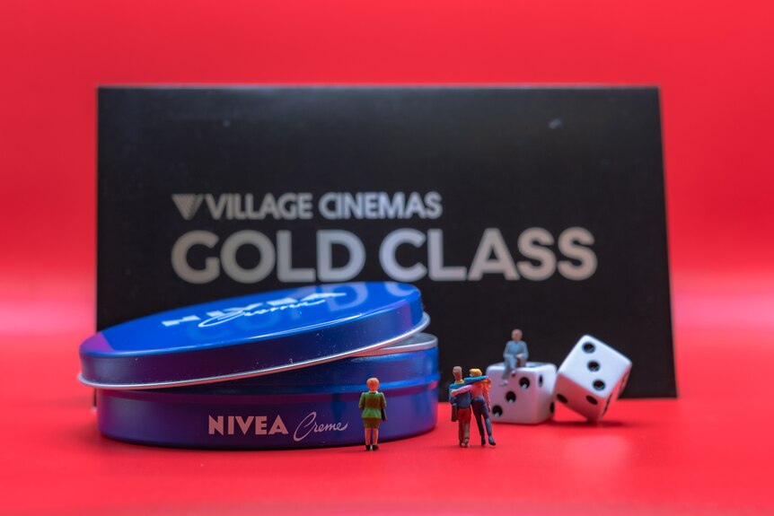 A photo of miniature people with cinema tickets.