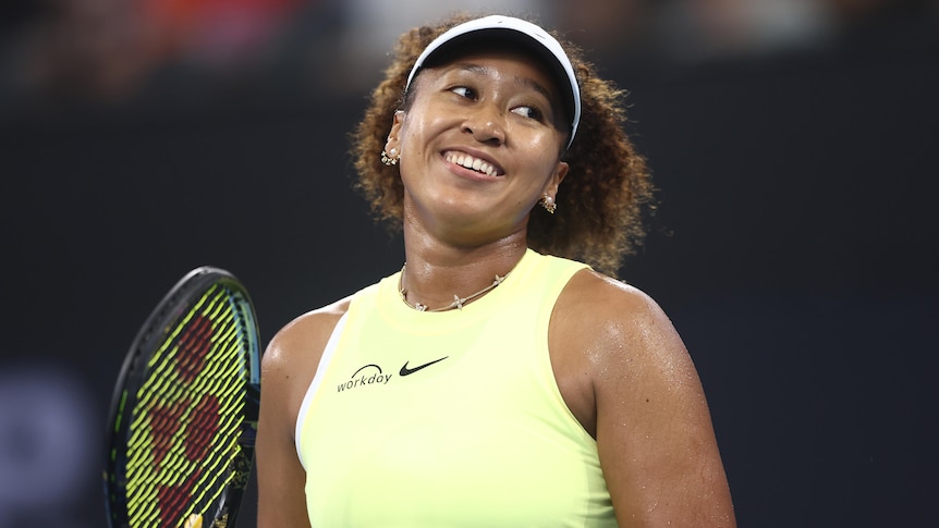 Tennis star Naomi Osaka smiles as she looks off court after a point during a match in Brisbane.