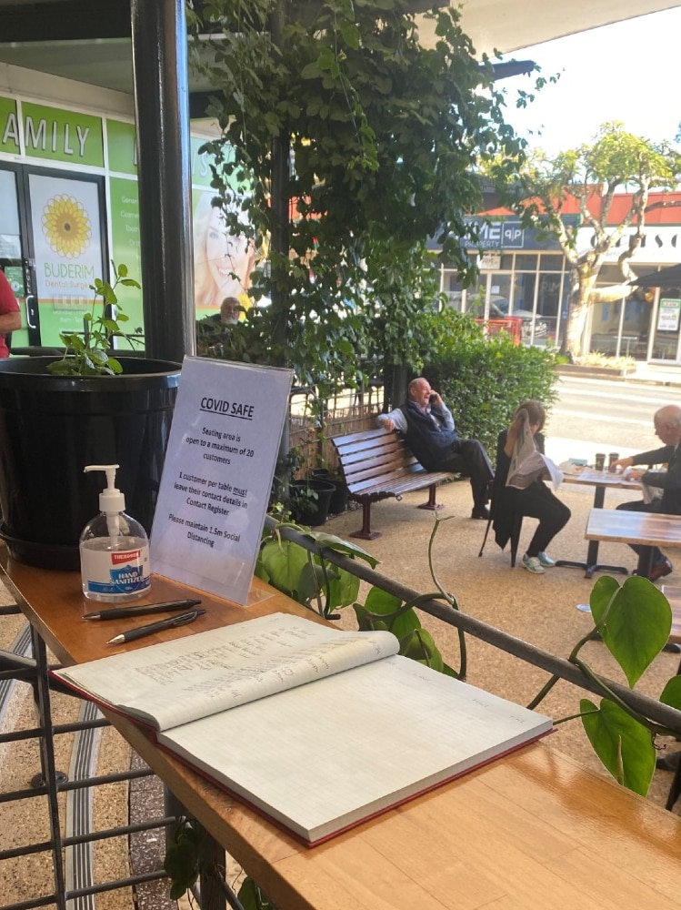 A book on a bench with people sitting at tables