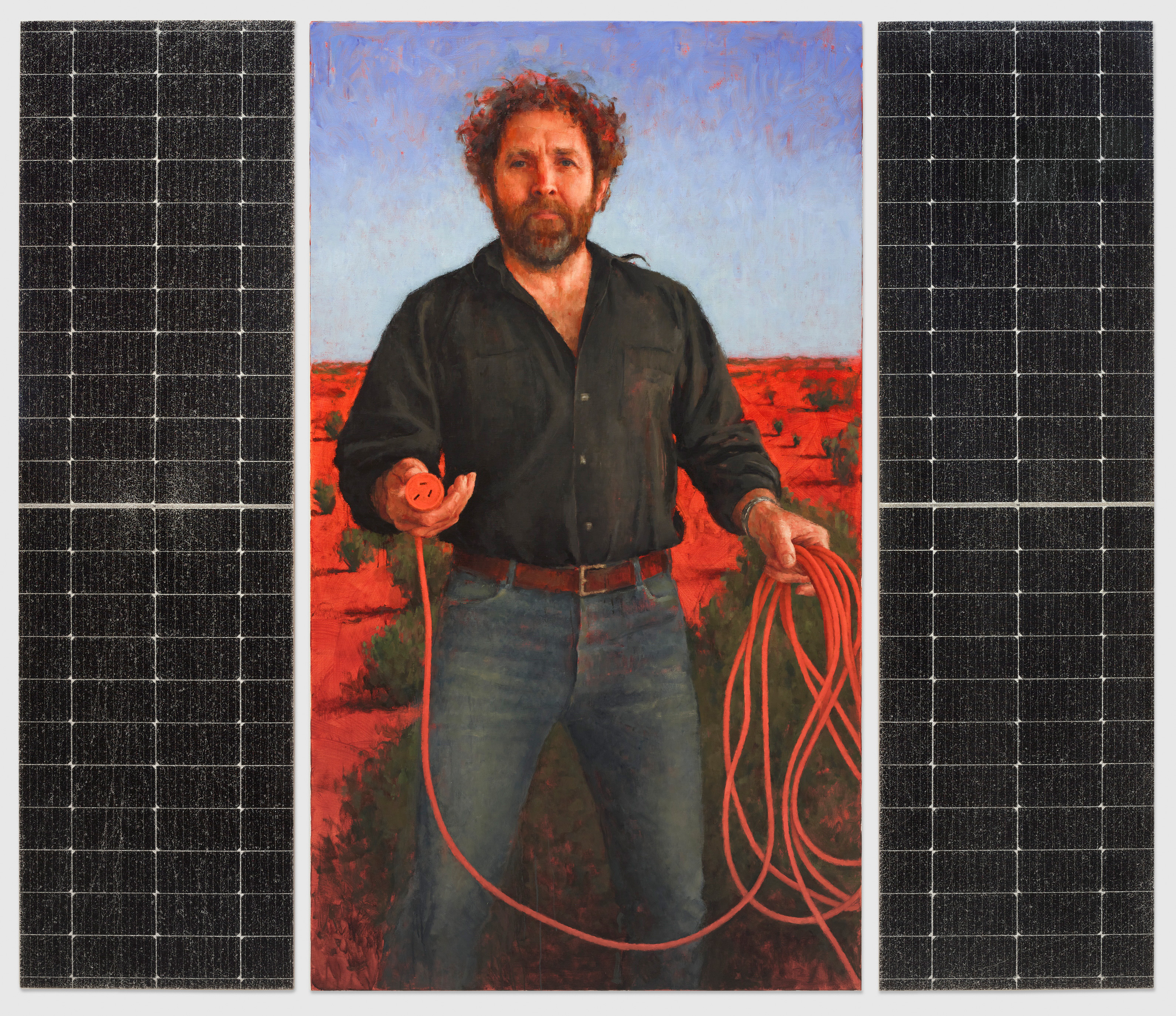 Barzdoto vidutinio amžiaus vyro užpakalyje, laikančio raudoną elektros laidą, portretas