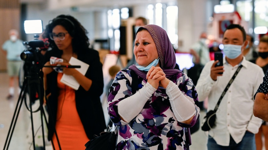 A woman waits for family members to arrive at Sydney airport