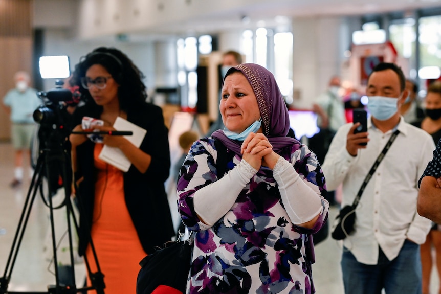 A woman waits for family members to arrive at Sydney airport