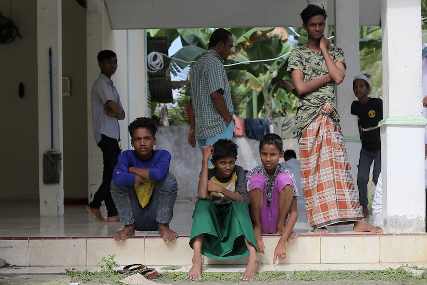 Young Rohingya refugees sit at a camp