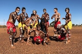 A group of 10 Indigenous men and boys pose painted up for a dance.