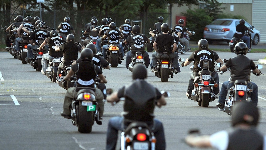 Bikes ride down a street.