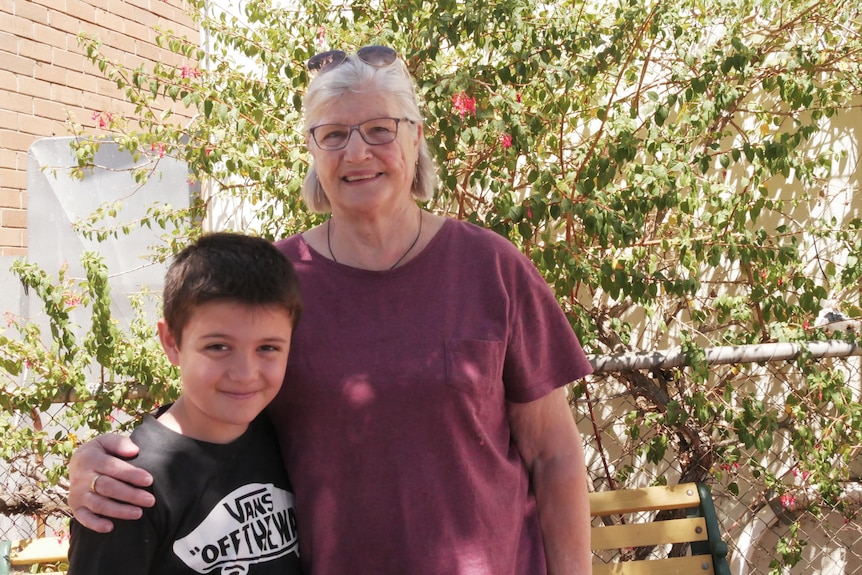 a woman stands with a young boy