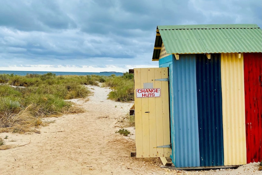 Stormy photo of beach with colourful beach shack.