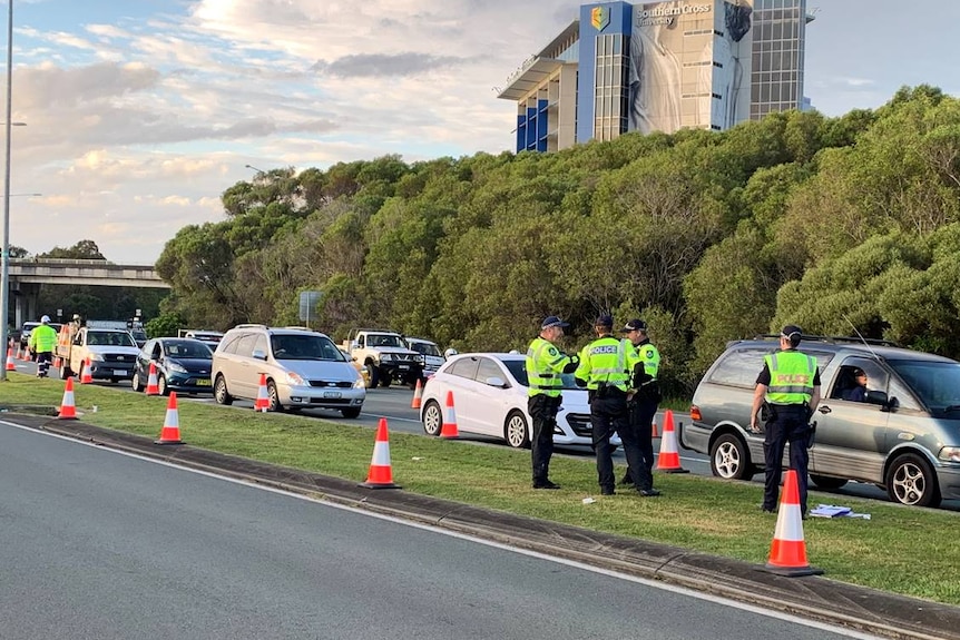 Cars wait in long queue, police speak to drivers at checkpoint