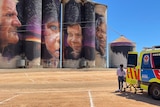 An ambulance sits on the right, with the silo artworks loom in the background 