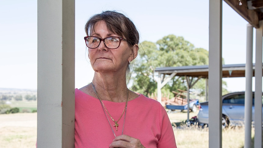 Amanda Johnston on her veranda, looking into distance.