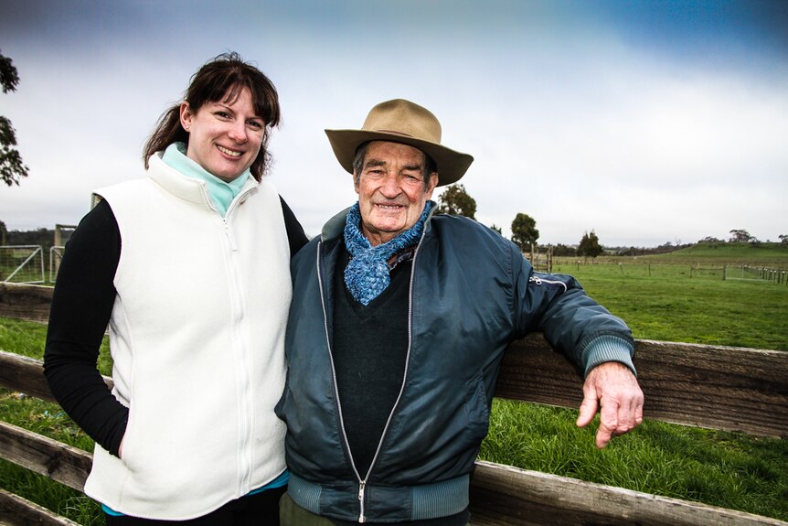 Melissa Connors and Noel Jenner leaning against a paddock fence.