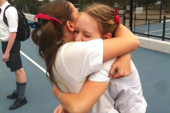 Schoolgirl Ellie Jensen hugs a friend in the playground.