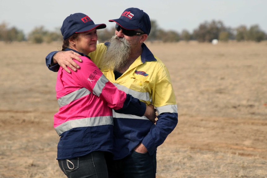 A couple embrace after completing the drive from outback WA